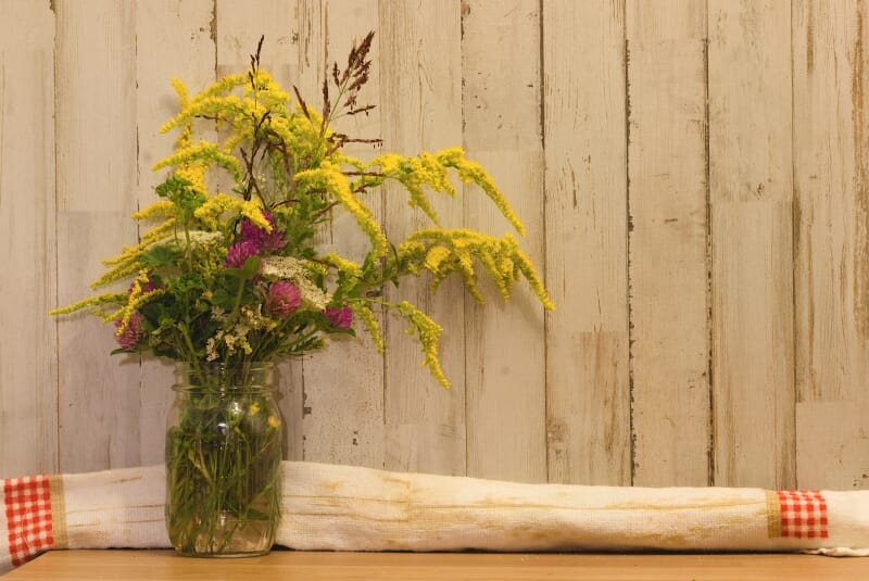 Rustic fall-themed dining room ideas: add some flowers in a mason jar and gingham patterned towels - LightsOnline Blog
